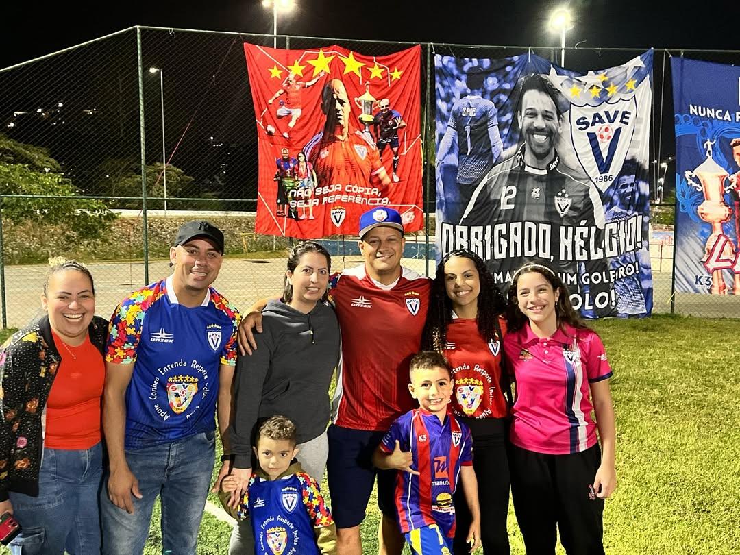 Italo e sua família com a homenagem feita pelo clube ao fundo
